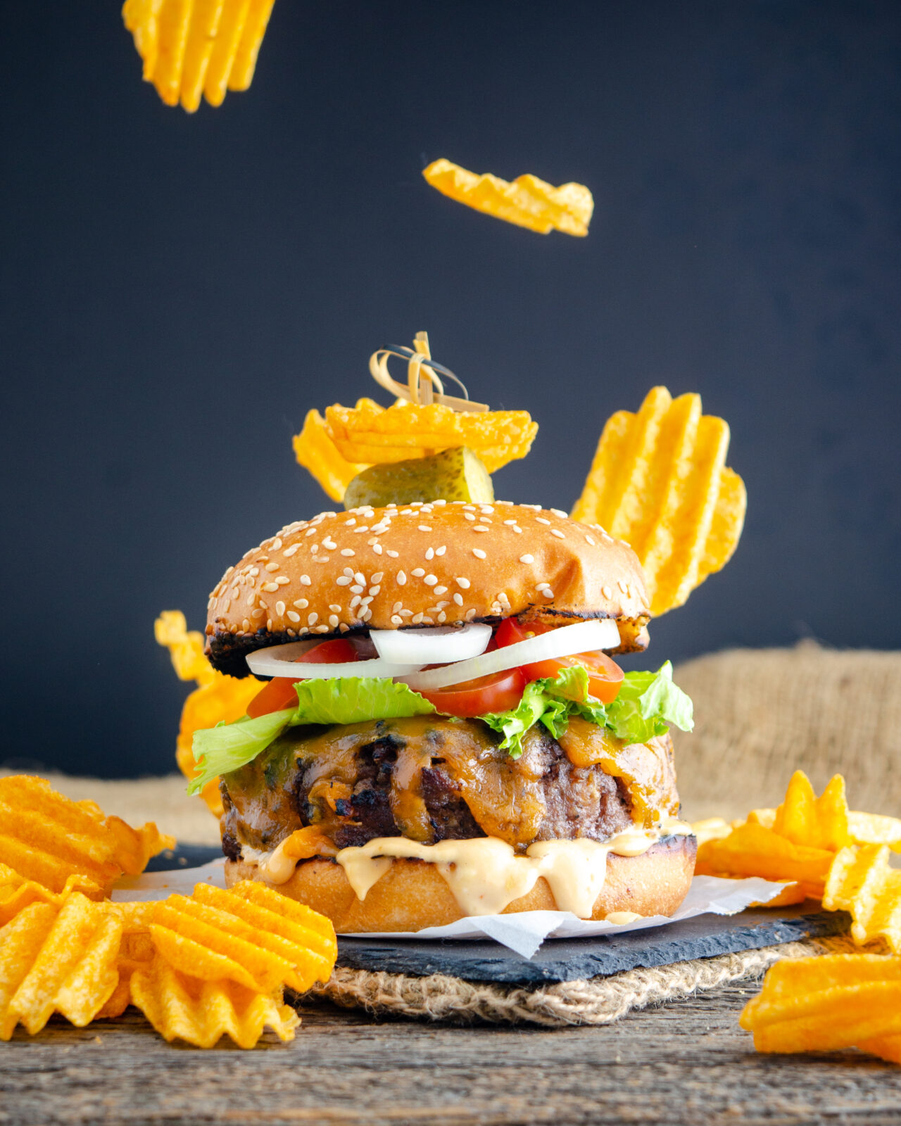 Food photography of a Fully loaded burger garnished with chips