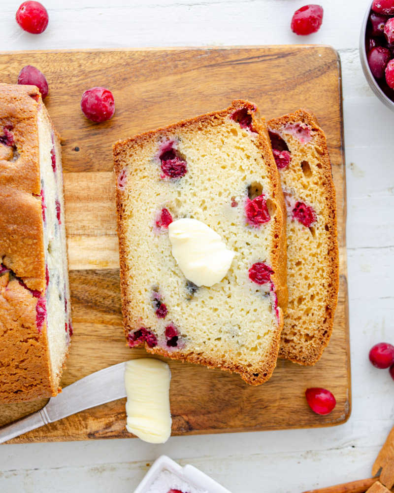Cream cheese cranberry loaf sliced on a cutting board.