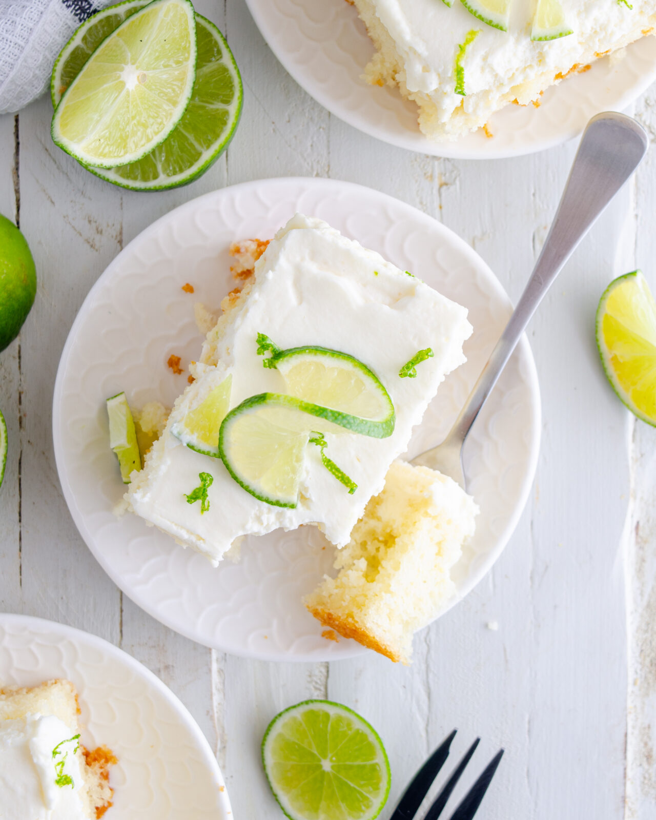 Key lime poke cake food photography on a white plate.