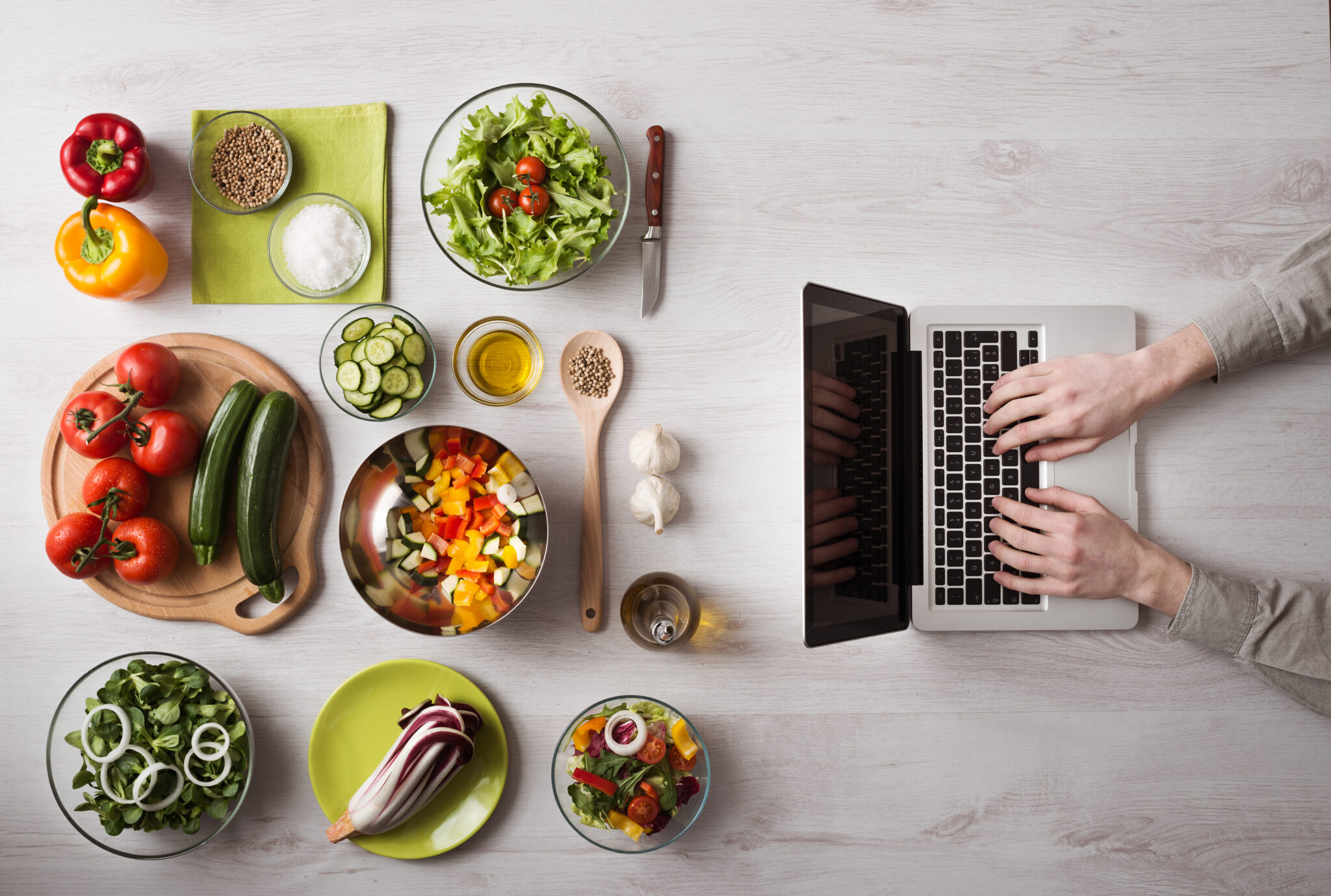 A counter top of food with a laptop in front of it, a user is typing