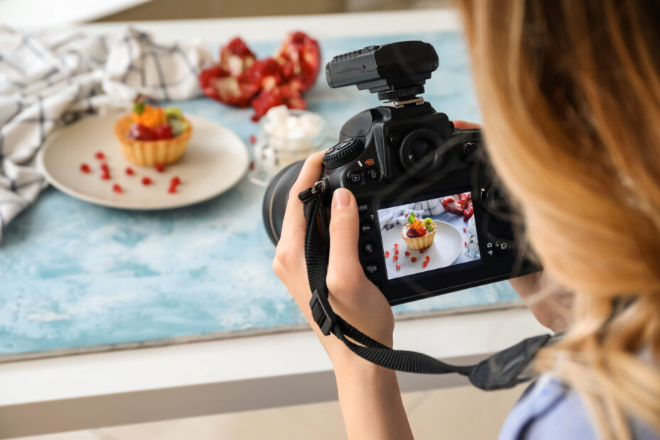 Female food photographer working in home studio shooting a tart with a camera